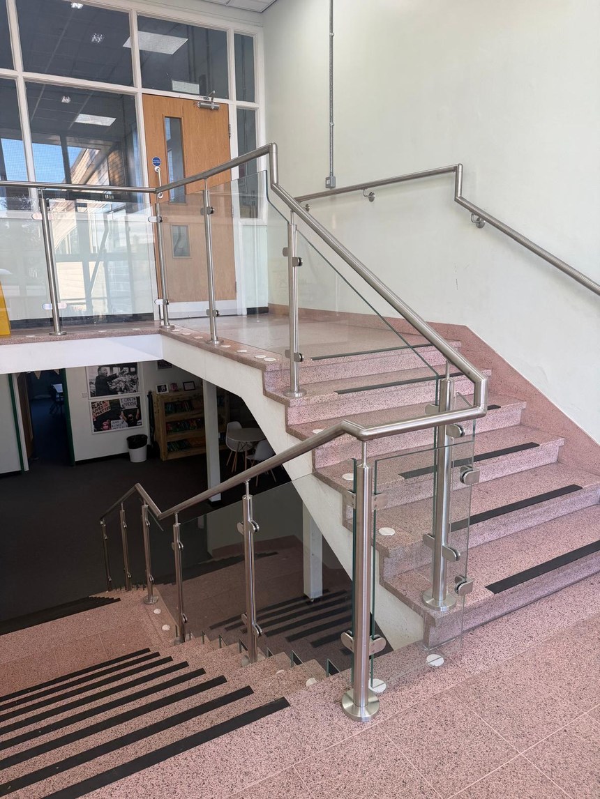 Stainless steel and glass balustrade to a half landing and flights in a primary school stair core